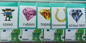 Afrikan tähti -pelin laminoituja setelejä ja jalokivikortteja.